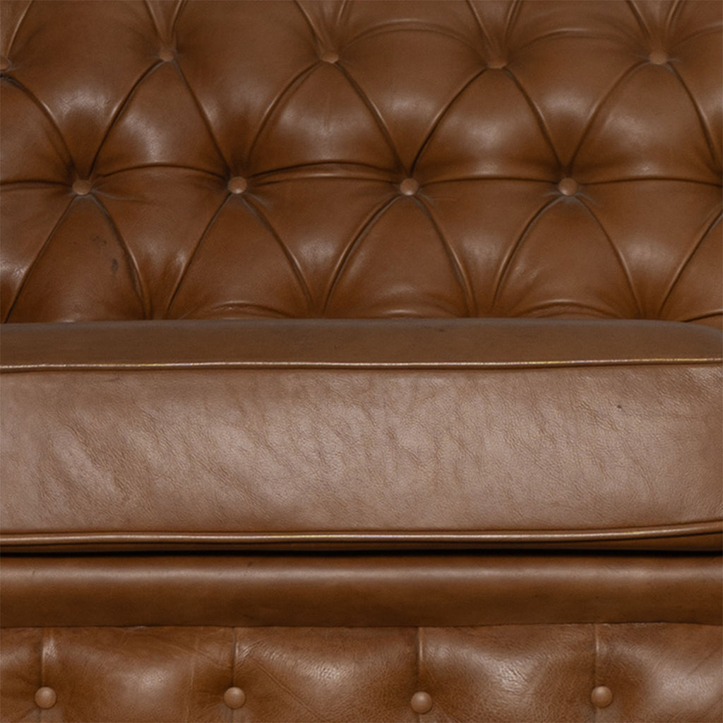 Brown leather sofa with tufted backrest